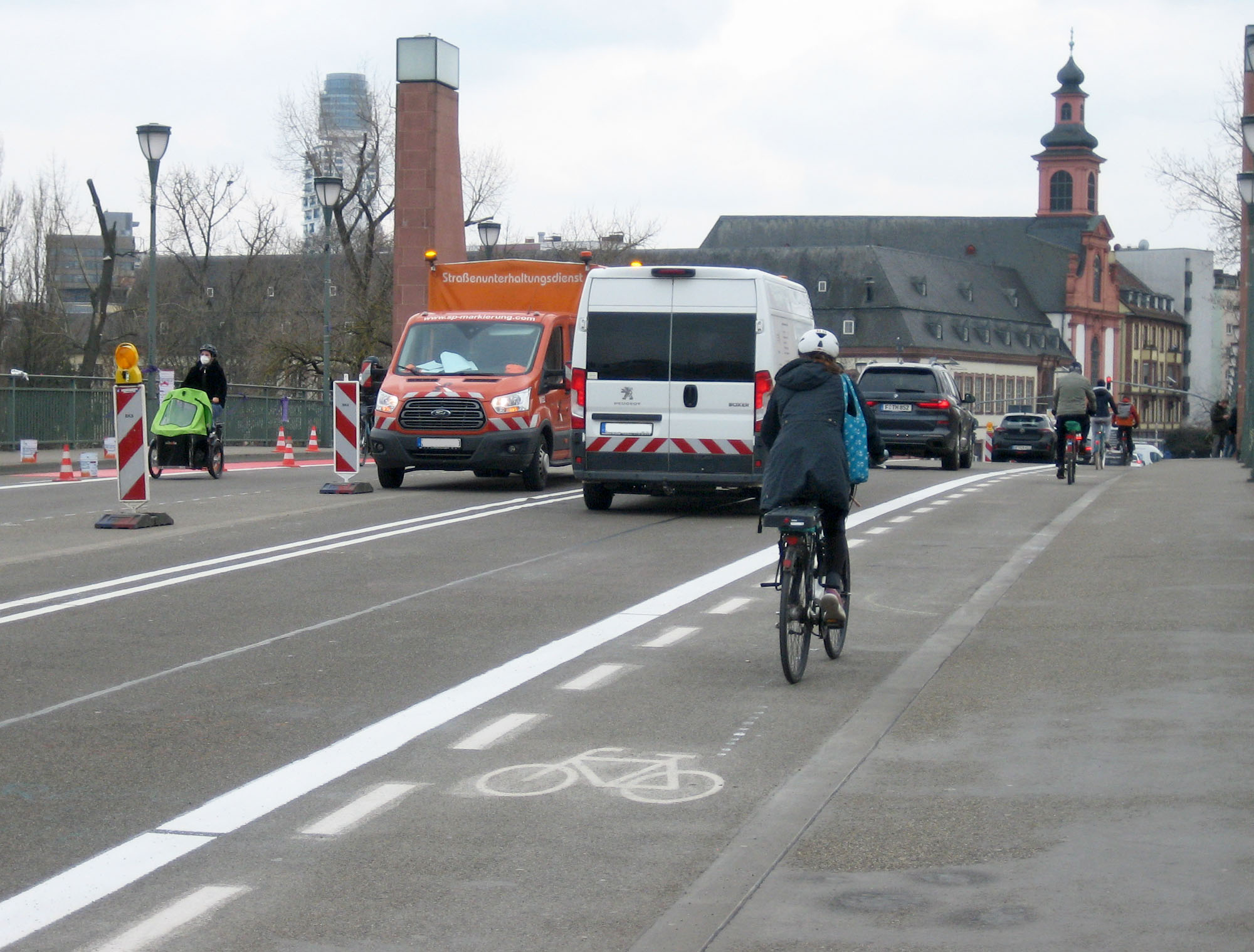 Der alte schmale Schutzstreifen auf der Alten Brücke ist schon demarkiert, der neue Radstreifen hat schon den Breitstrich, auf der Gegenseite wird schon die rote Farbe aufgetragen. Ein Teil der letzten Maßnahme in einer aus Radverkehrssicht ziemlich erfolgreichen Wahlperiode Fotos: Torsten Willner/Bertram Giebeler