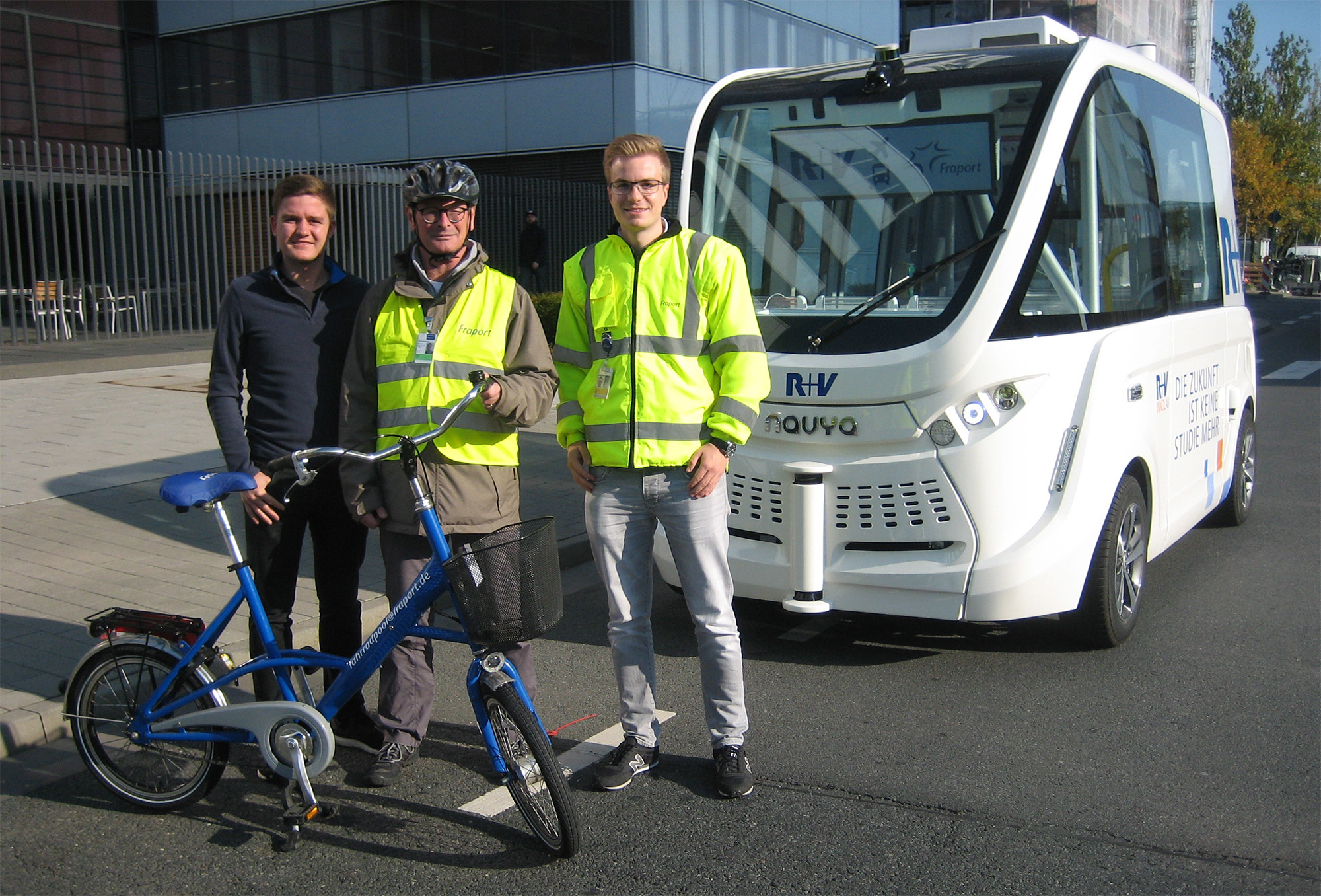 Vor der Probefahrt, v.l.: Marcel Heinz, R+V, MO14 Innovation Lab; Proberadler Bertram Giebeler, ADFC Frankfurt (sicherheitshalber mit Helm); Manuel Wehner, Fraport Unternehmensentwicklung - Ideen- und Innovationsmanagement; der autonome Bus von Navya, Villeurbanne, Frankreich