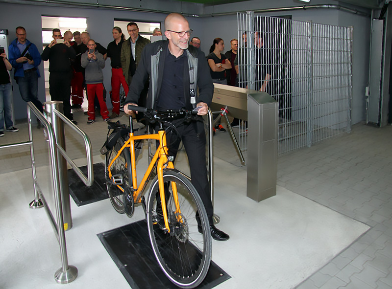 Verkehrsdezernent Stefan Majer schiebt das erste Fahrrad durch die Sperre der neuen Abstellanlage am Frankfurter Hauptbahnhof.