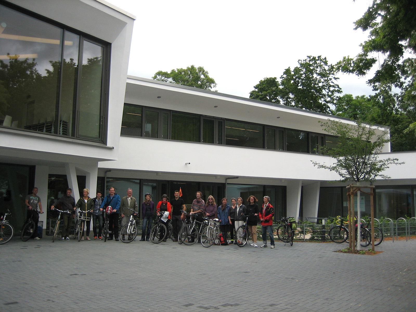 "TDA-Tour 29.06.14": Die Gruppe aus Architekten und interessierten Laien am Sonntag den 29. Juni vor dem neu gebauten Gemeindezentrum der evangelischen Dankeskirche in Goldstein. Links neben dem ADFC-Wimpel Architekt Thomas Beha vom Architekturbüro Frick + Frick, Frankfurt