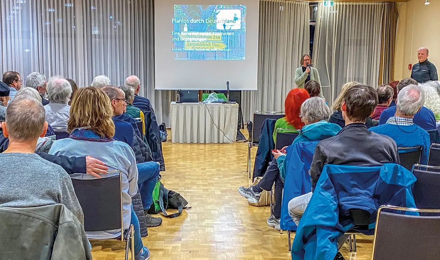 Vera Dopichaj begrüßt den gut gefüllten Saal zum „Planlos“-Vortrag von Andreas Dammer (rechts im Bild)<br><span class="image-copyright">Peter Sauer</span>