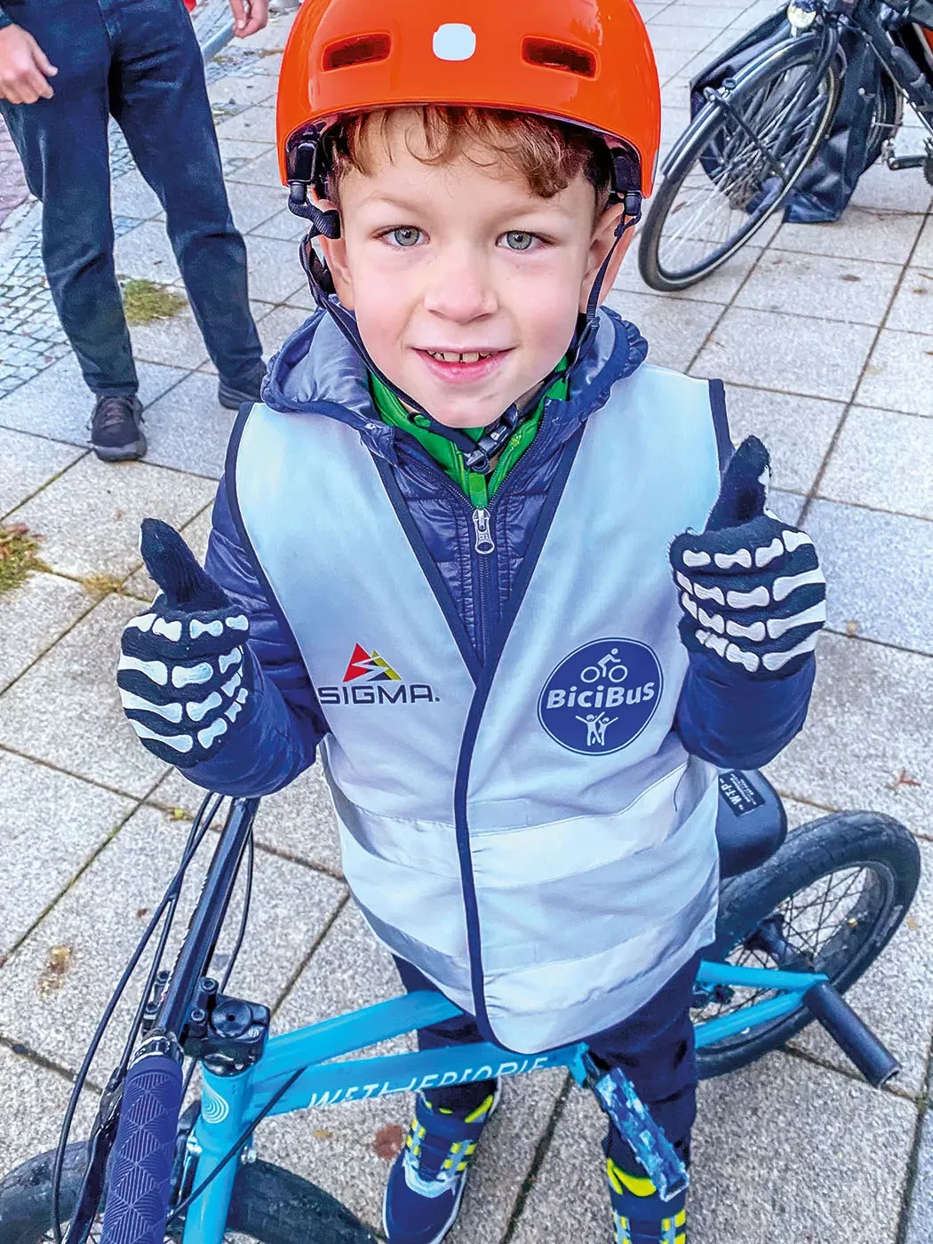 Ein Junge auf einem Fahrrad hält beide Daumen hoch