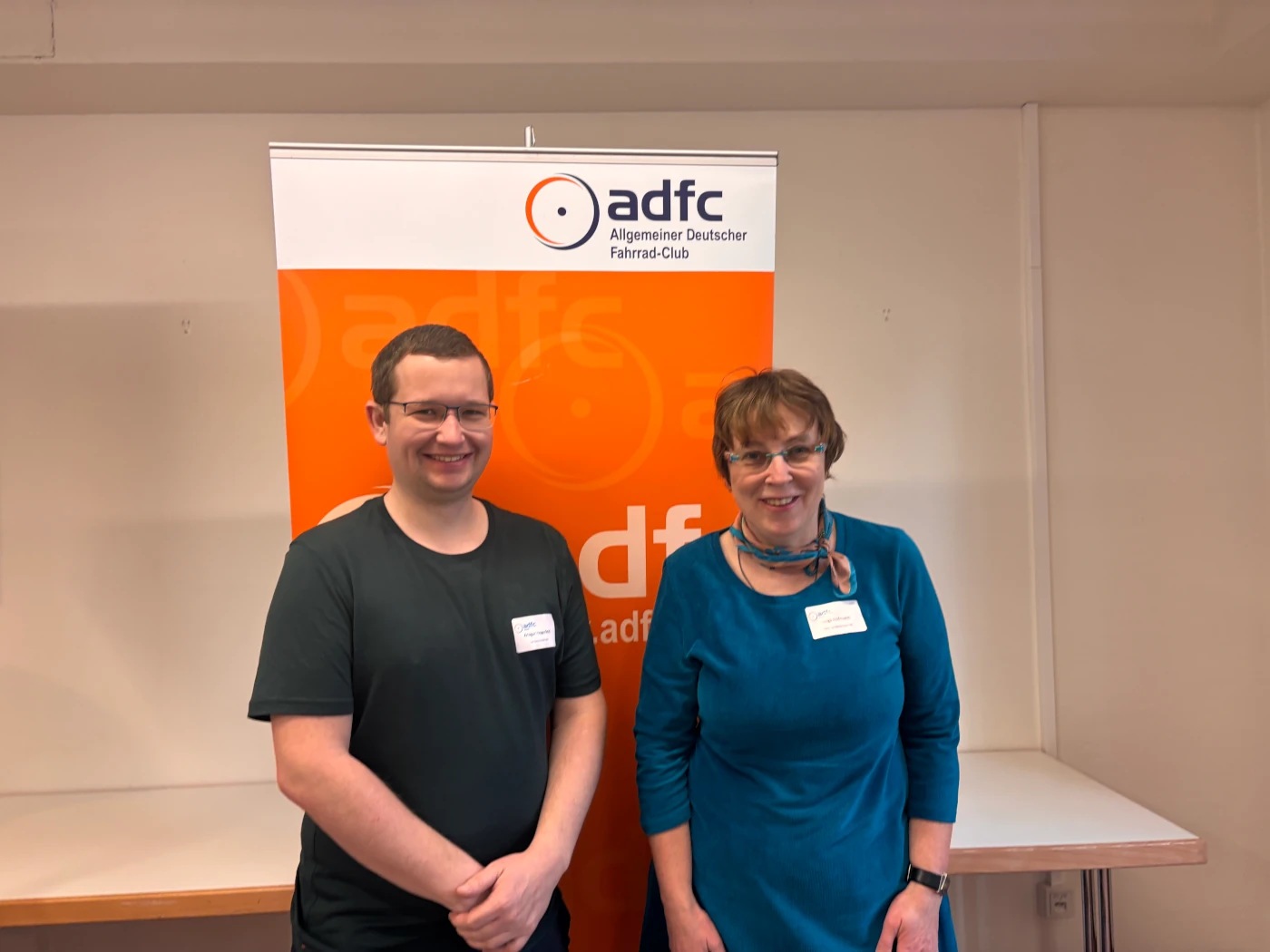 Die Landesvorsitzenden Ansgar Hegerfeld und Helga Hofmann stehen vor einem ADFC-Banner und begrüßen die Gäste