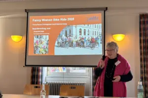 Die Referentin steht neben ihrer Präsentation