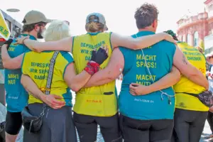 Rückenansicht fünf Personen die ein TShirt mit der Aufschrift „MUT-TOUR macht Spaß“ tragen